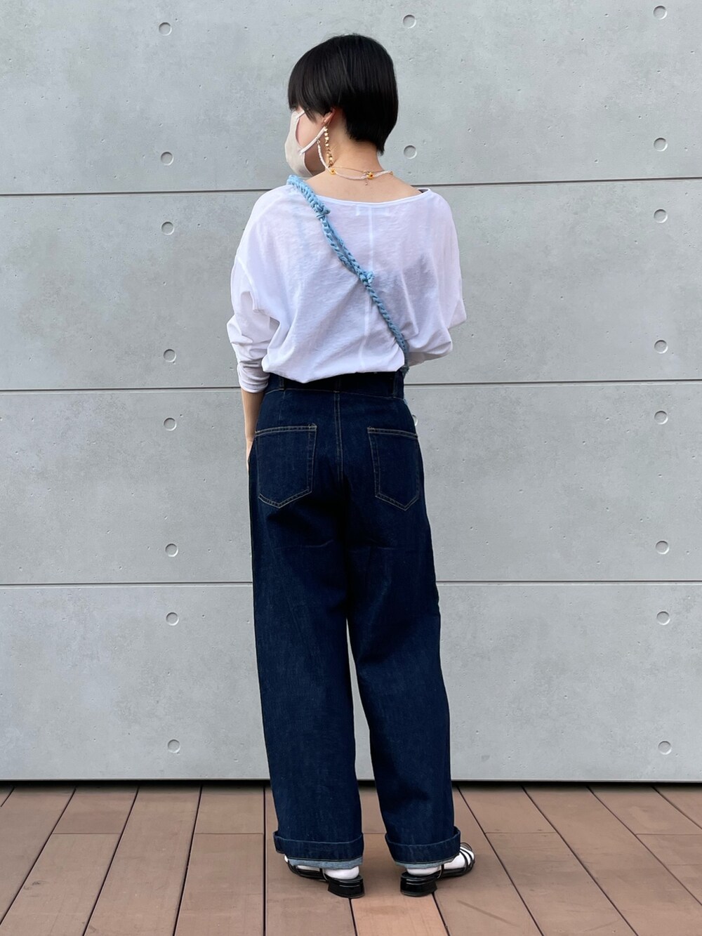 ホワイト系のTシャツ/カットソー、ブルー系のデニムパンツ、ブラック系のサンダルを着用したレディースの春コーディネートの3枚目の写真