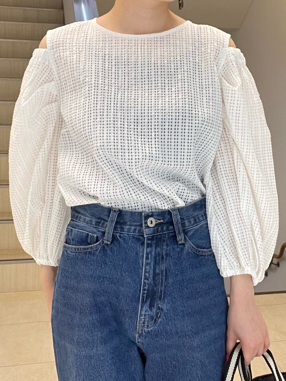 ホワイト系のシャツ/ブラウス、ブルー系のデニムパンツ、ブラック系のトートバッグを着用したレディースの春コーディネートの4枚目の写真