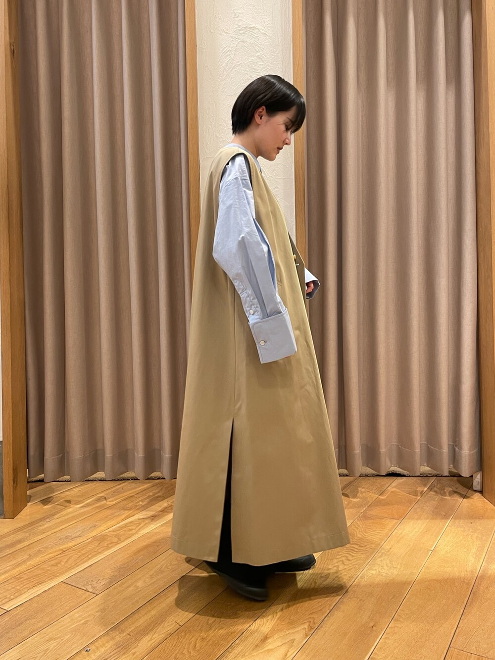 ベージュ系のトレンチコート、ブルー系のシャツ/ブラウスを着用したレディースの春コーディネートの2枚目の写真