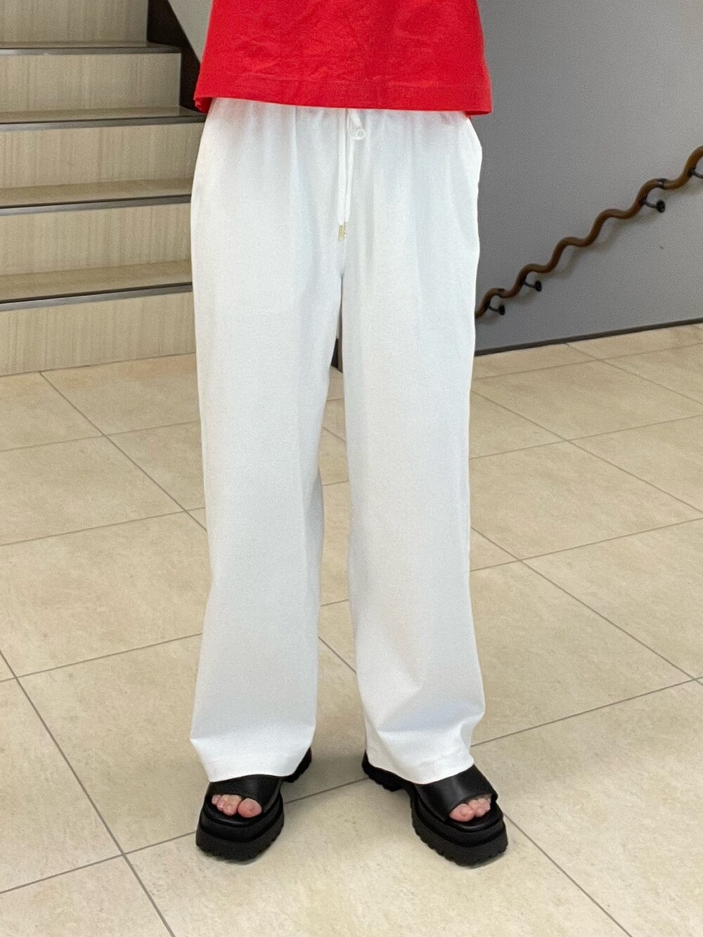 レッド系のシャツ/ブラウス、ホワイト系のスラックス、ブラック系のサンダルを着用したレディースの春コーディネートの4枚目の写真