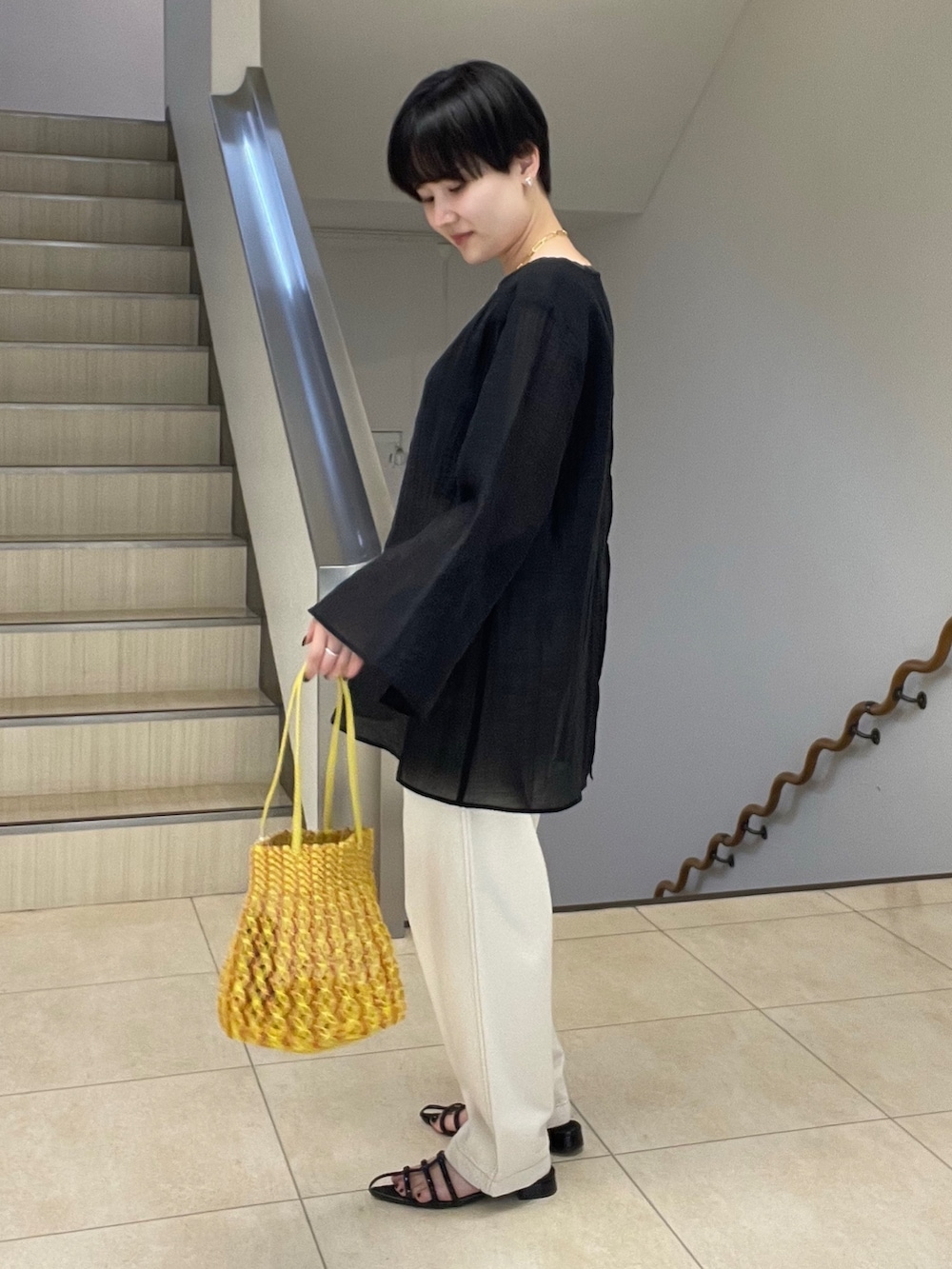 ブラック系のシャツ/ブラウス、ホワイト系のデニムパンツ、イエロー系のショルダーバッグを着用したレディースの春コーディネートの2枚目の写真