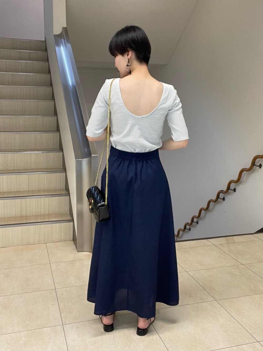 ホワイト系のTシャツ/カットソー、ブルー系のスカート、ブラック系のショルダーバッグを着用したレディースの春コーディネートの3枚目の写真