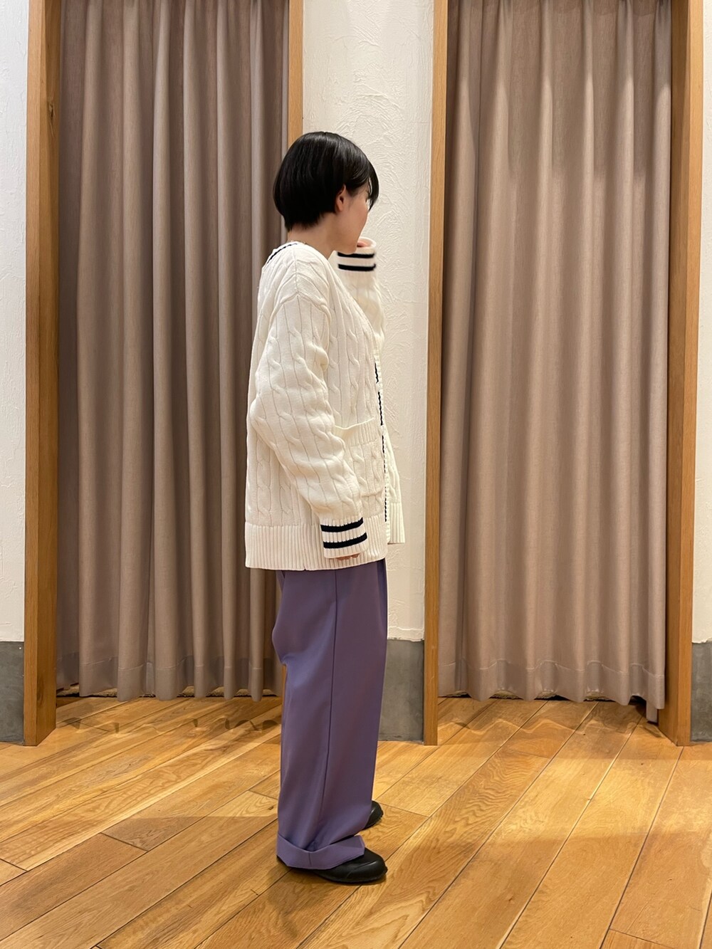 ホワイト系のカーディガン/ボレロ、パープル系のスラックスを着用したレディースの春コーディネートの2枚目の写真