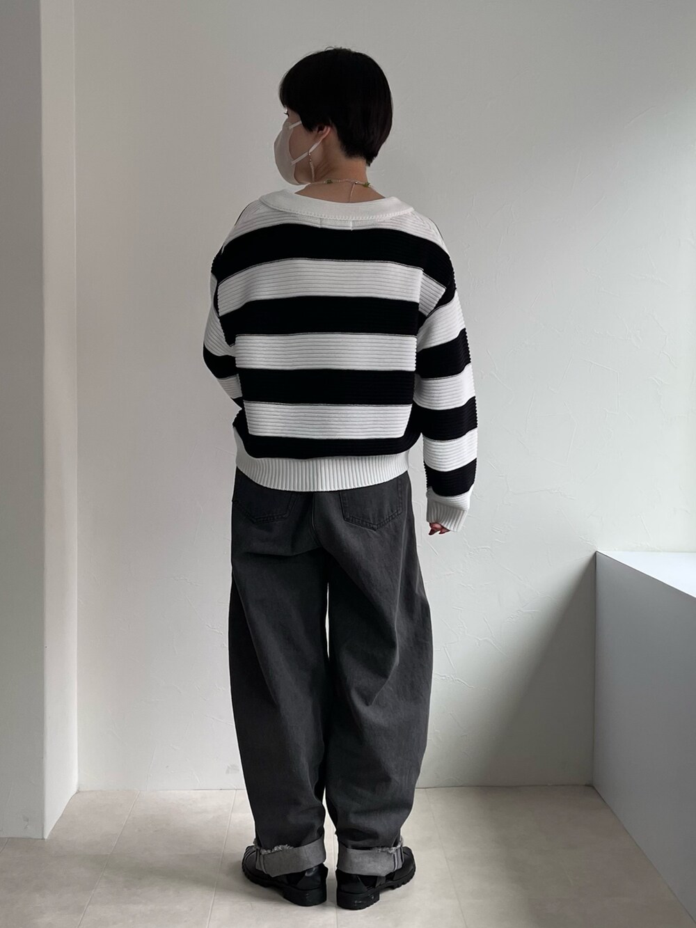 ホワイト系のニット/セーター、ブラック系のデニムパンツを着用したレディースの春コーディネートの3枚目の写真
