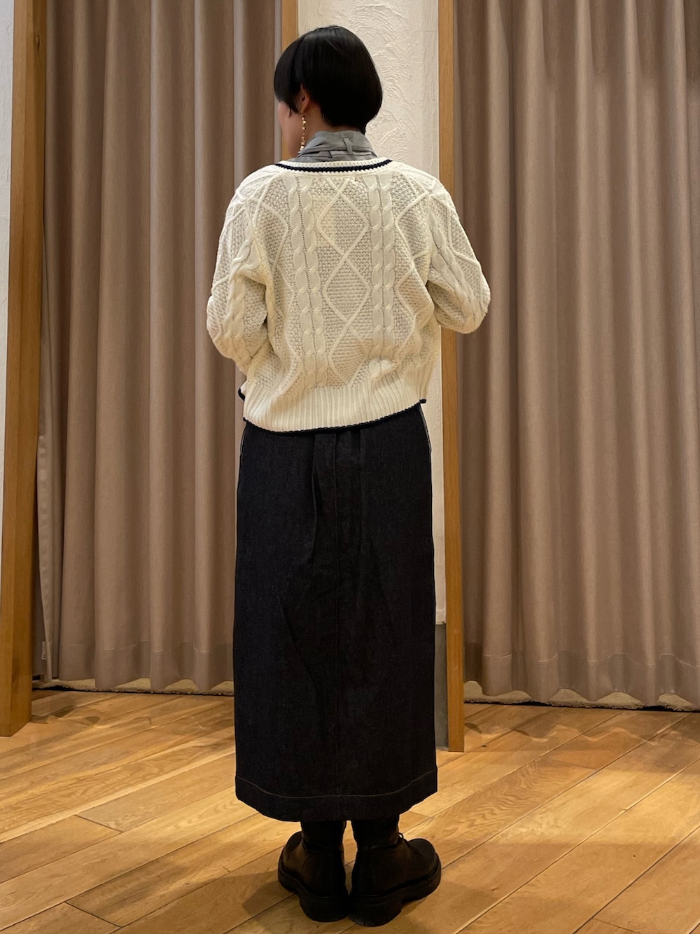 ホワイト系のカーディガン/ボレロ、グレー系のシャツ/ブラウス、ブルー系のデニムスカートを着用したレディースの冬コーディネートの3枚目の写真