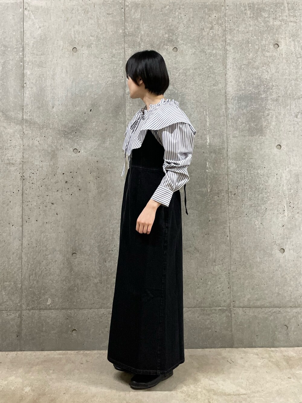 ホワイト系のシャツ/ブラウス、ブラック系のジャンパースカートを着用したレディースの春コーディネートの2枚目の写真