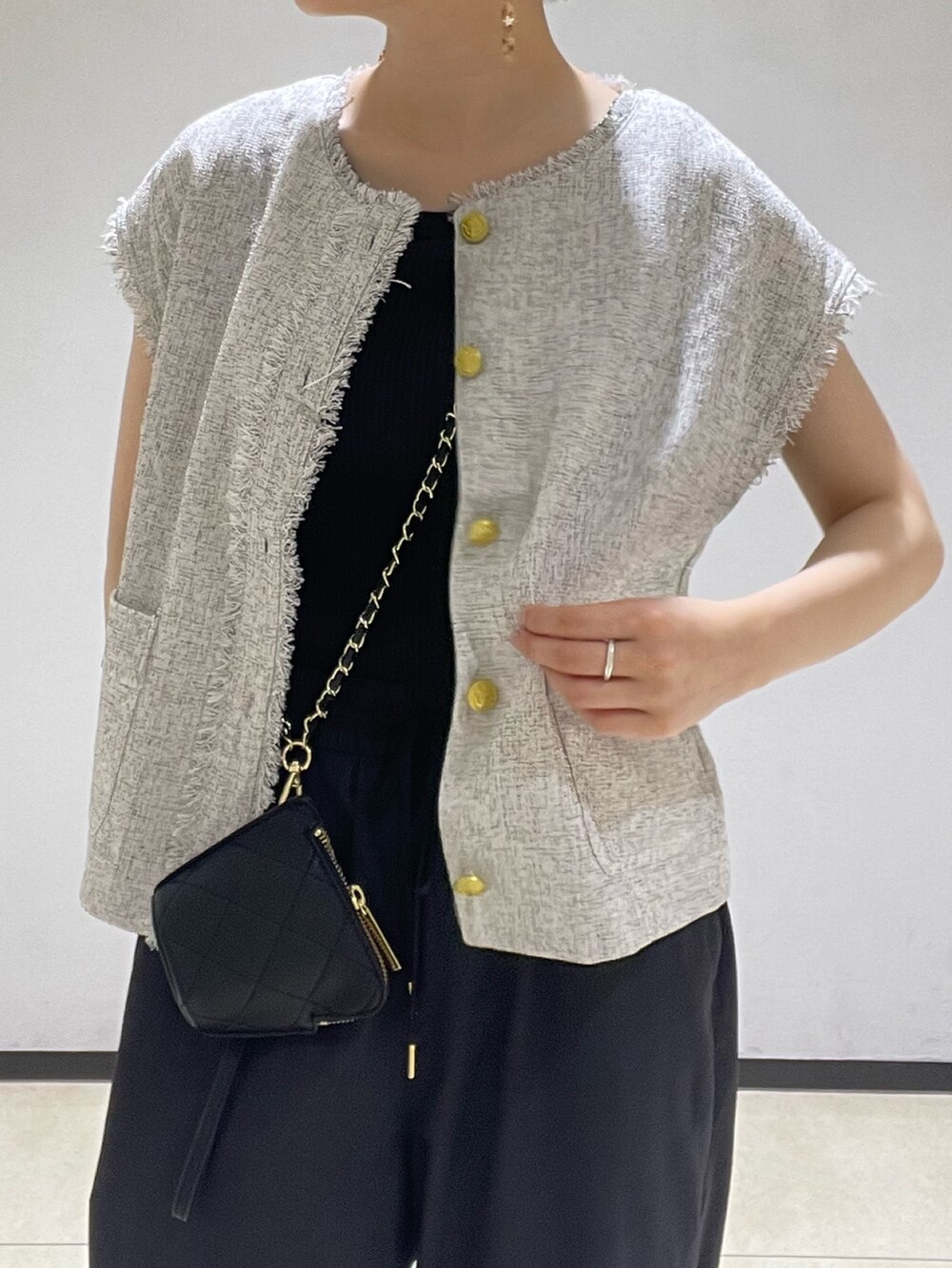 グレー系のシャツ/ブラウス、ブラック系のスラックス、ブラック系のサンダルを着用したレディースの夏コーディネートの4枚目の写真