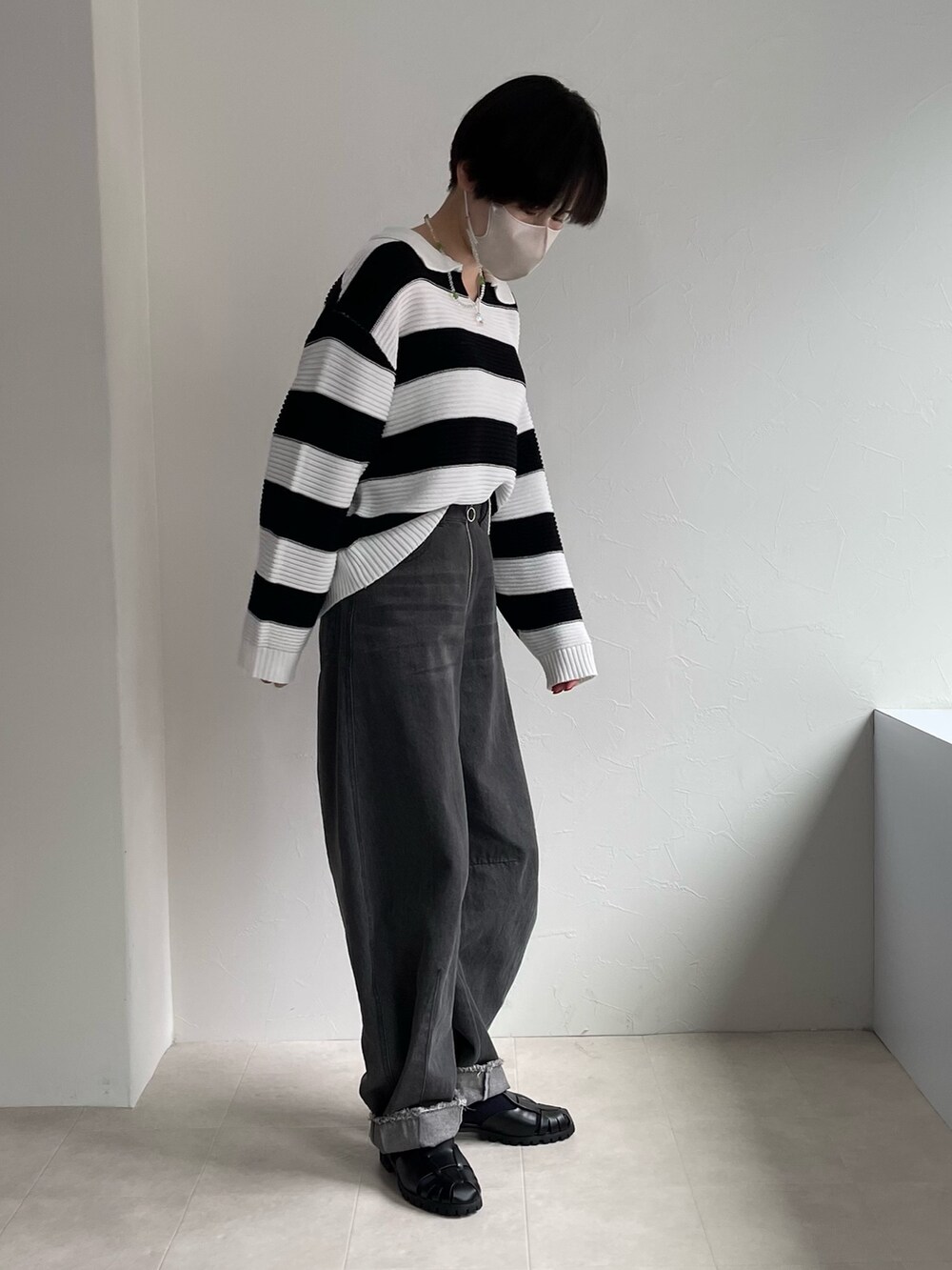 ホワイト系のニット/セーター、ブラック系のデニムパンツを着用したレディースの春コーディネートの2枚目の写真