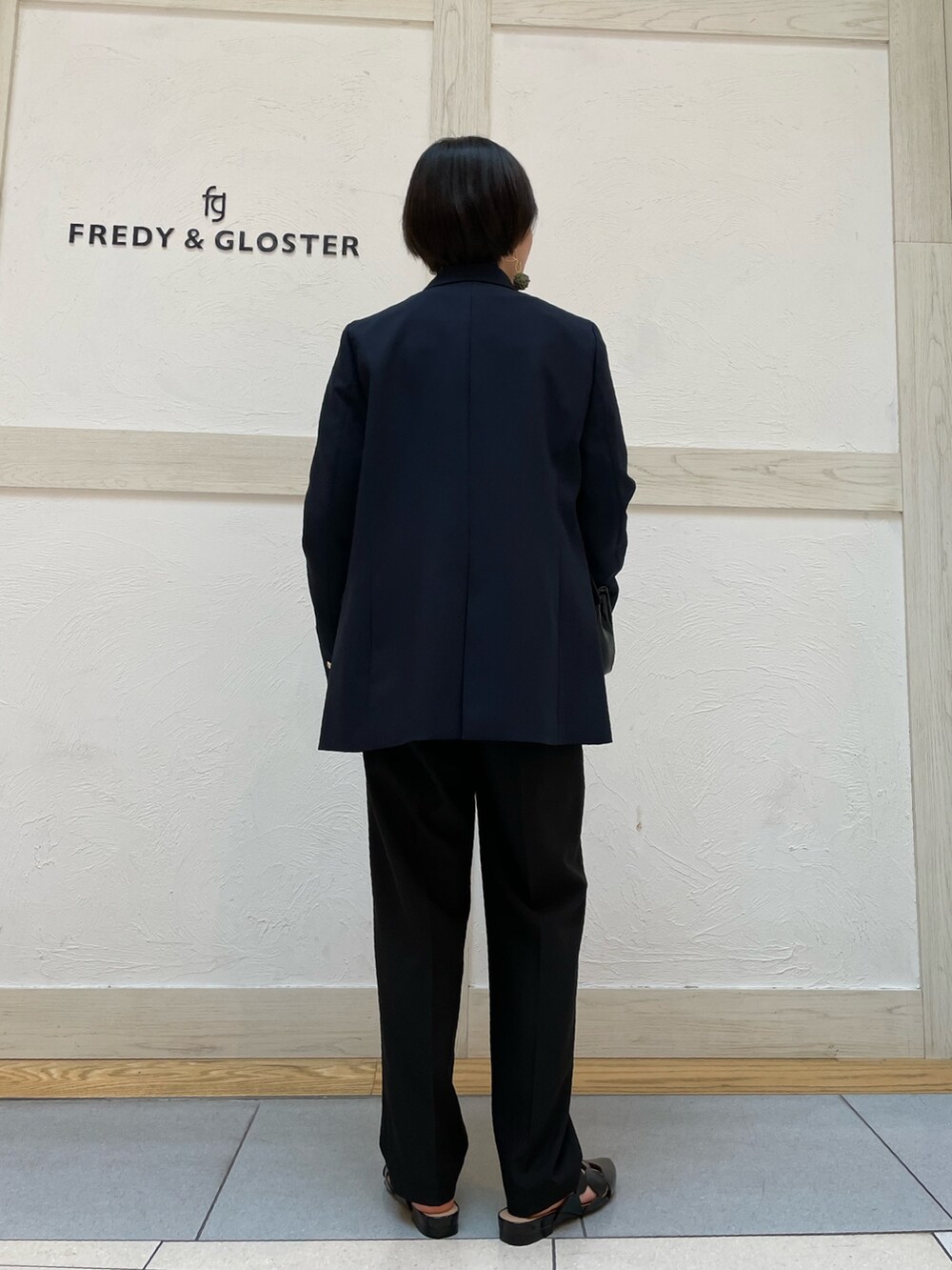 グリーン系のTシャツ/カットソー、ブルー系のテーラードジャケット、ブラック系のスラックスを着用したレディースの春コーディネートの3枚目の写真