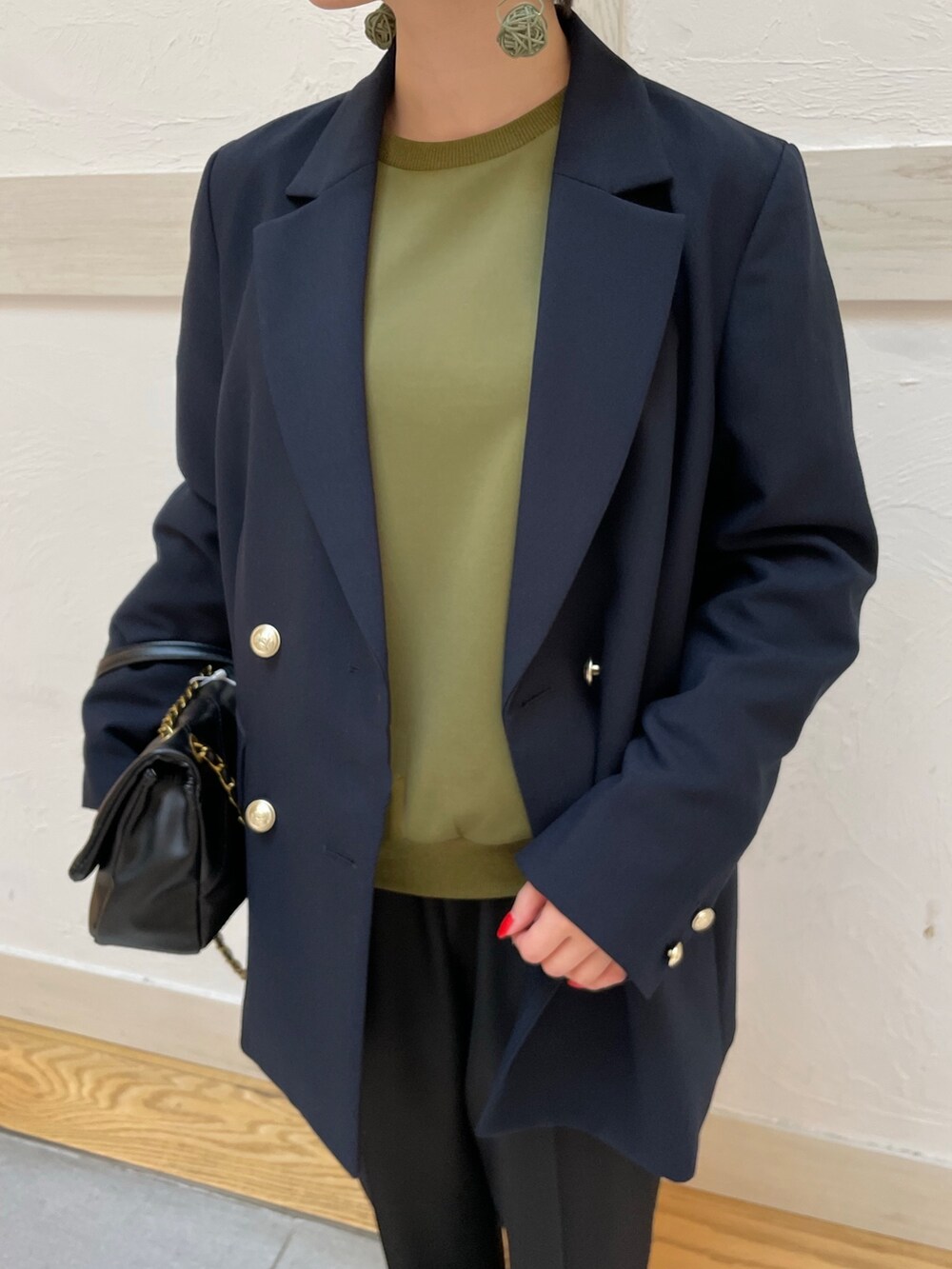 グリーン系のTシャツ/カットソー、ブルー系のテーラードジャケット、ブラック系のスラックスを着用したレディースの春コーディネートの4枚目の写真