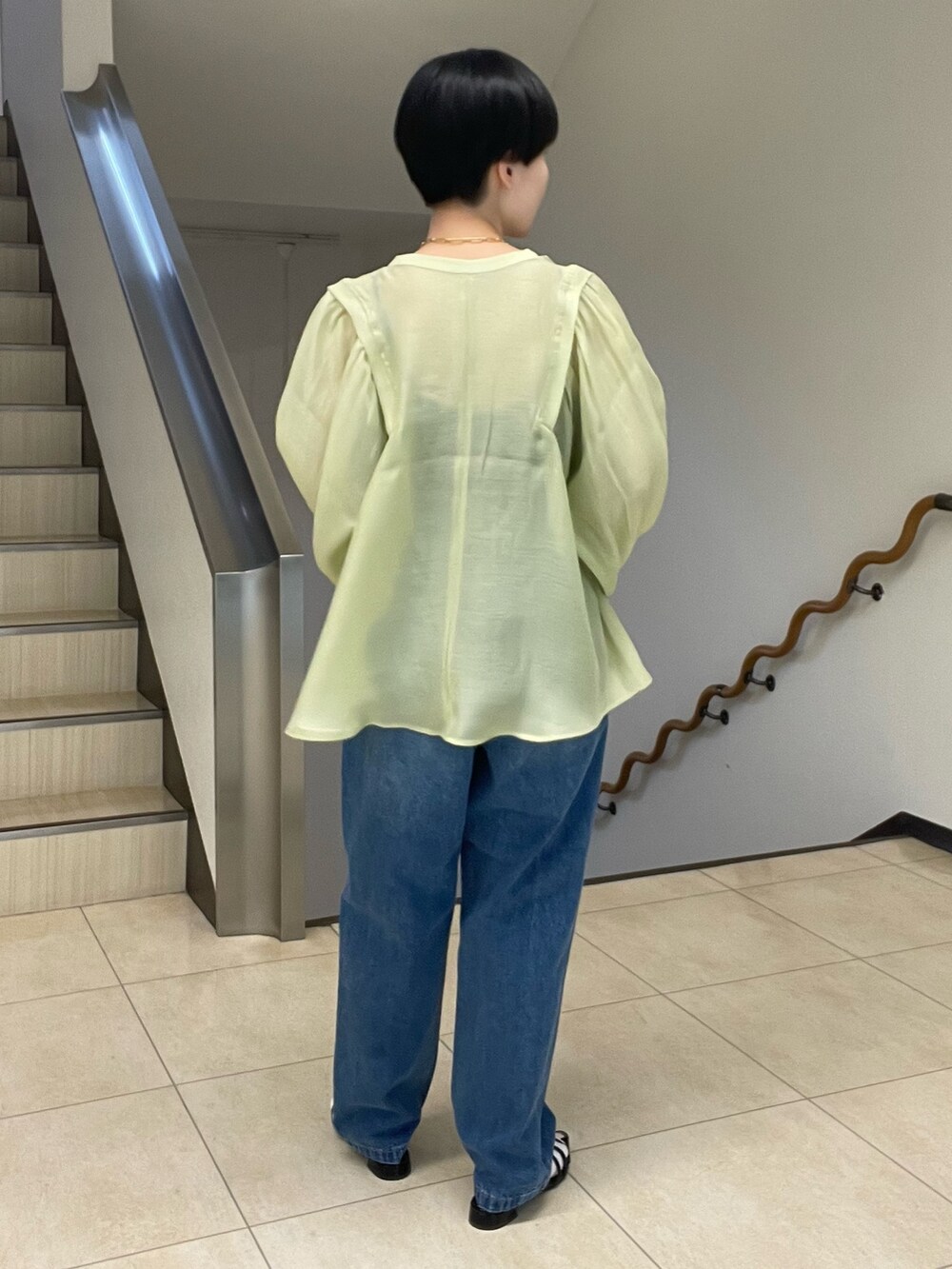 グリーン系のシャツ/ブラウス、ブルー系のデニムパンツ、ブラック系のサンダルを着用したレディースの春コーディネートの3枚目の写真