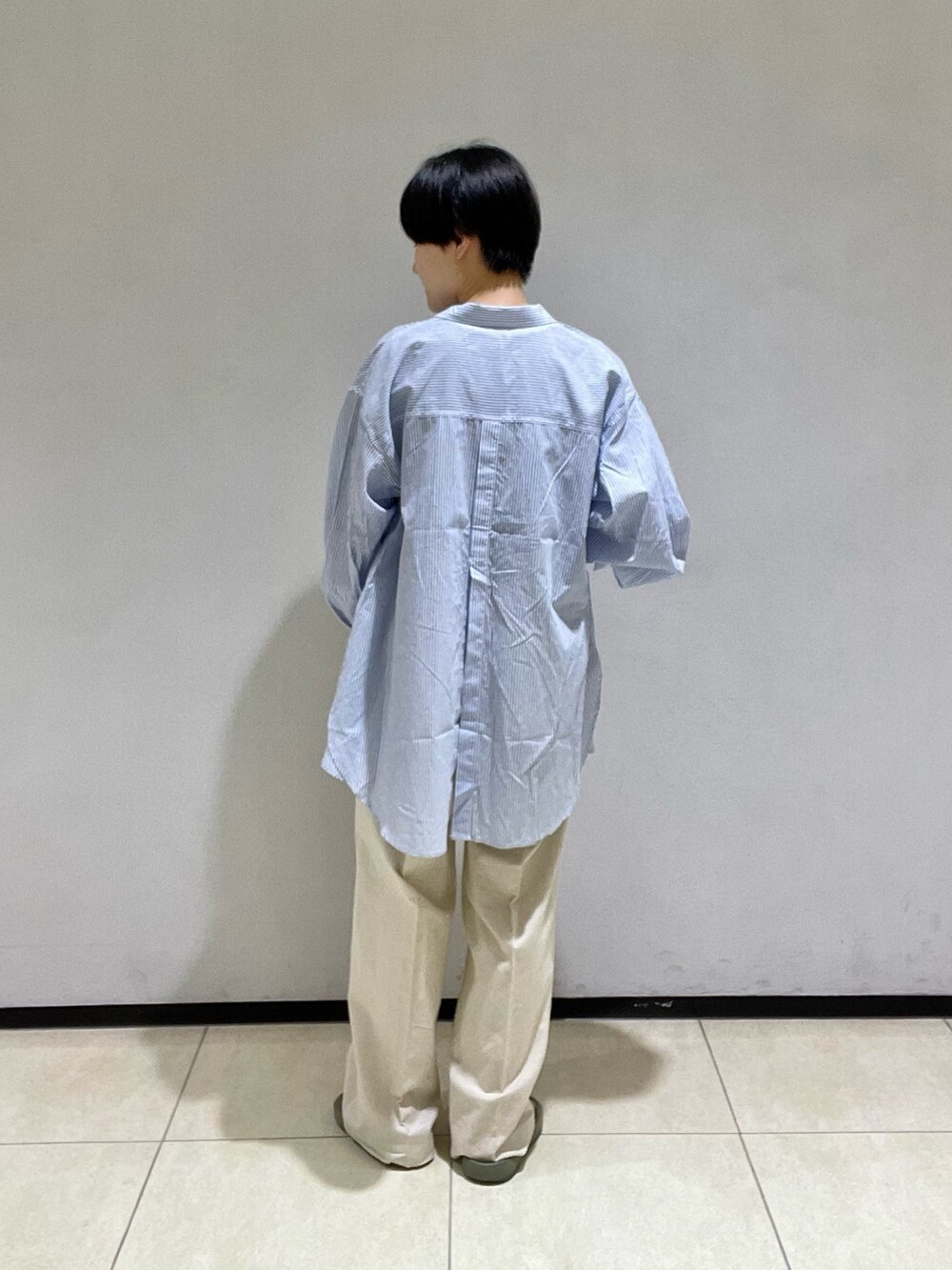 ブルー系のシャツ/ブラウス、ブラック系のTシャツ/カットソー、ベージュ系のスラックスを着用したレディースの夏コーディネートの3枚目の写真