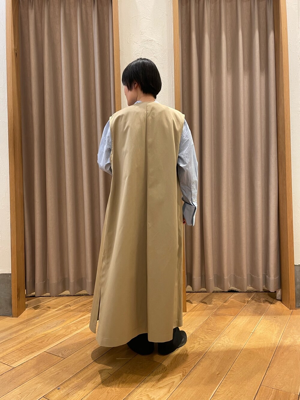 ベージュ系のトレンチコート、ブルー系のシャツ/ブラウスを着用したレディースの春コーディネートの3枚目の写真