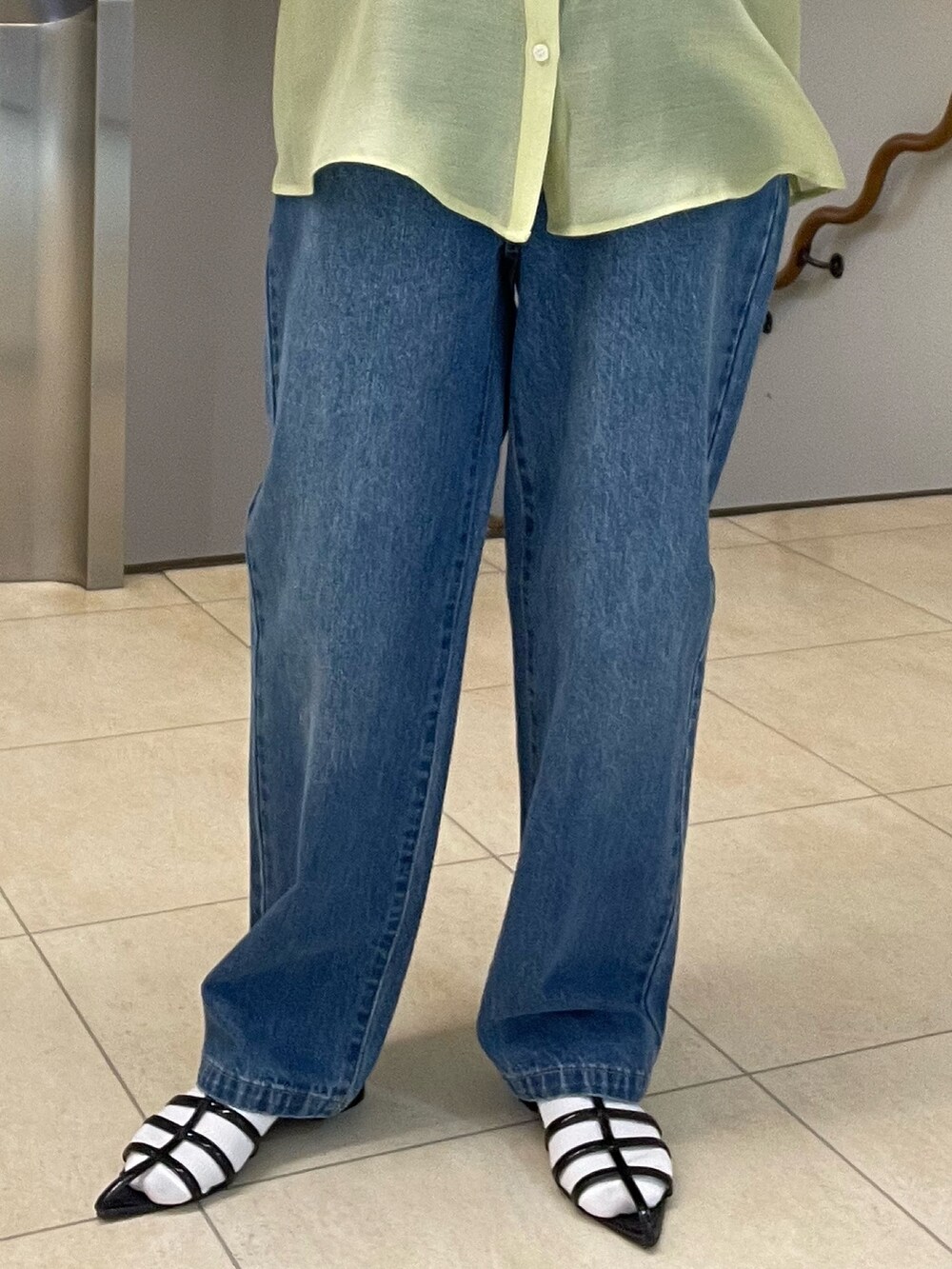 グリーン系のシャツ/ブラウス、ブルー系のデニムパンツ、ブラック系のサンダルを着用したレディースの春コーディネートの6枚目の写真