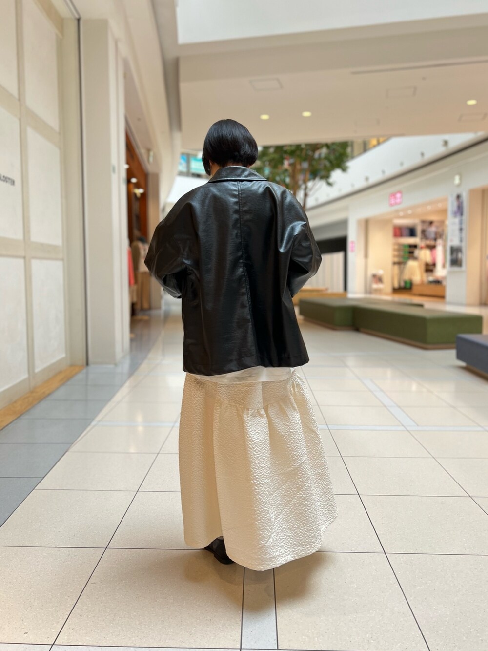 ブラック系のブルゾン、ホワイト系のスカート、ホワイト系のTシャツ/カットソーを着用したレディースの春コーディネートの3枚目の写真