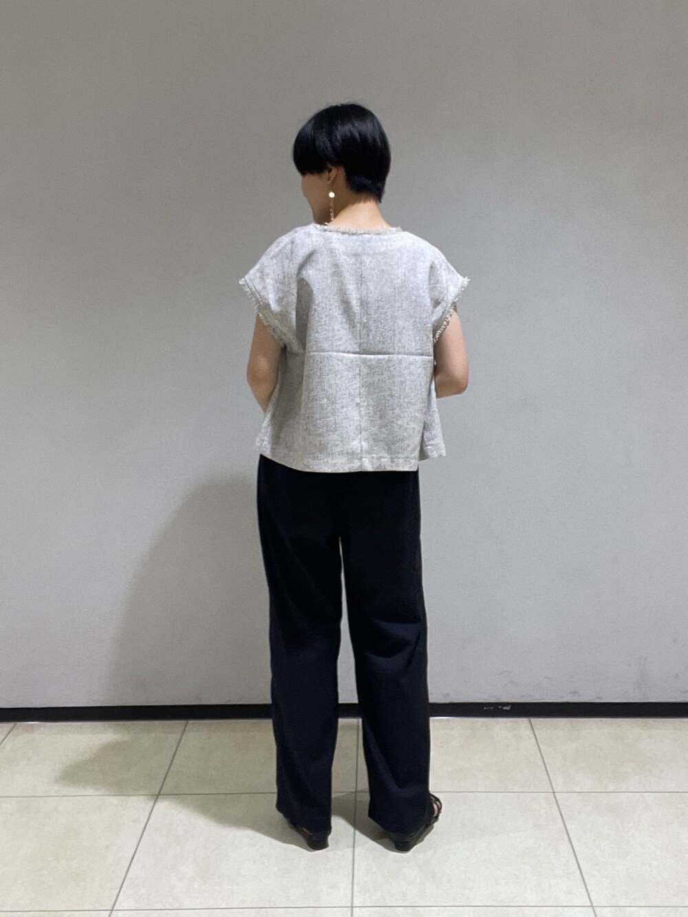 グレー系のシャツ/ブラウス、ブラック系のスラックス、ブラック系のサンダルを着用したレディースの夏コーディネートの3枚目の写真