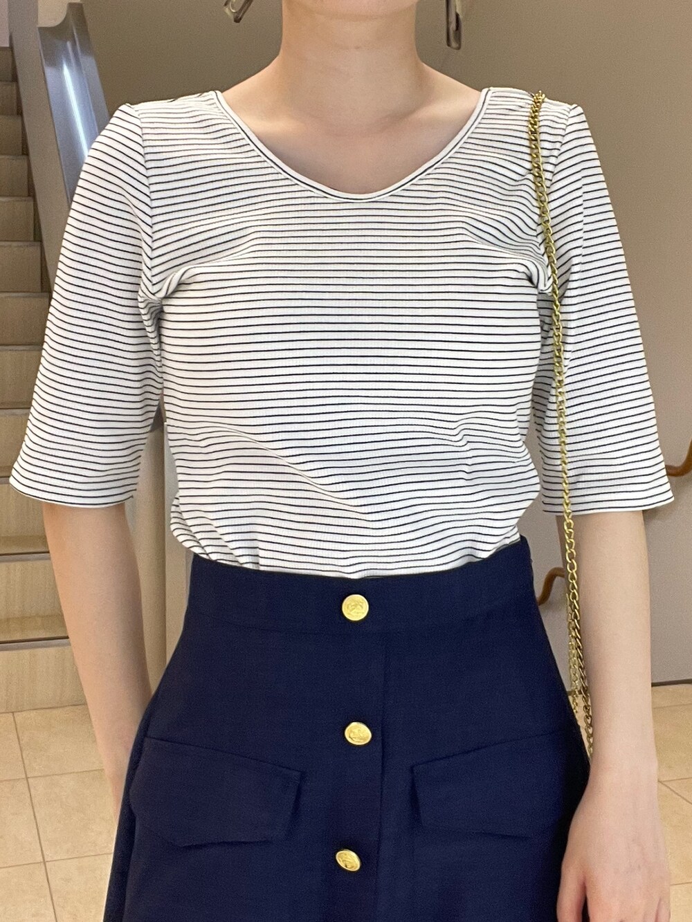 ホワイト系のTシャツ/カットソー、ブルー系のスカート、ブラック系のショルダーバッグを着用したレディースの春コーディネートの4枚目の写真