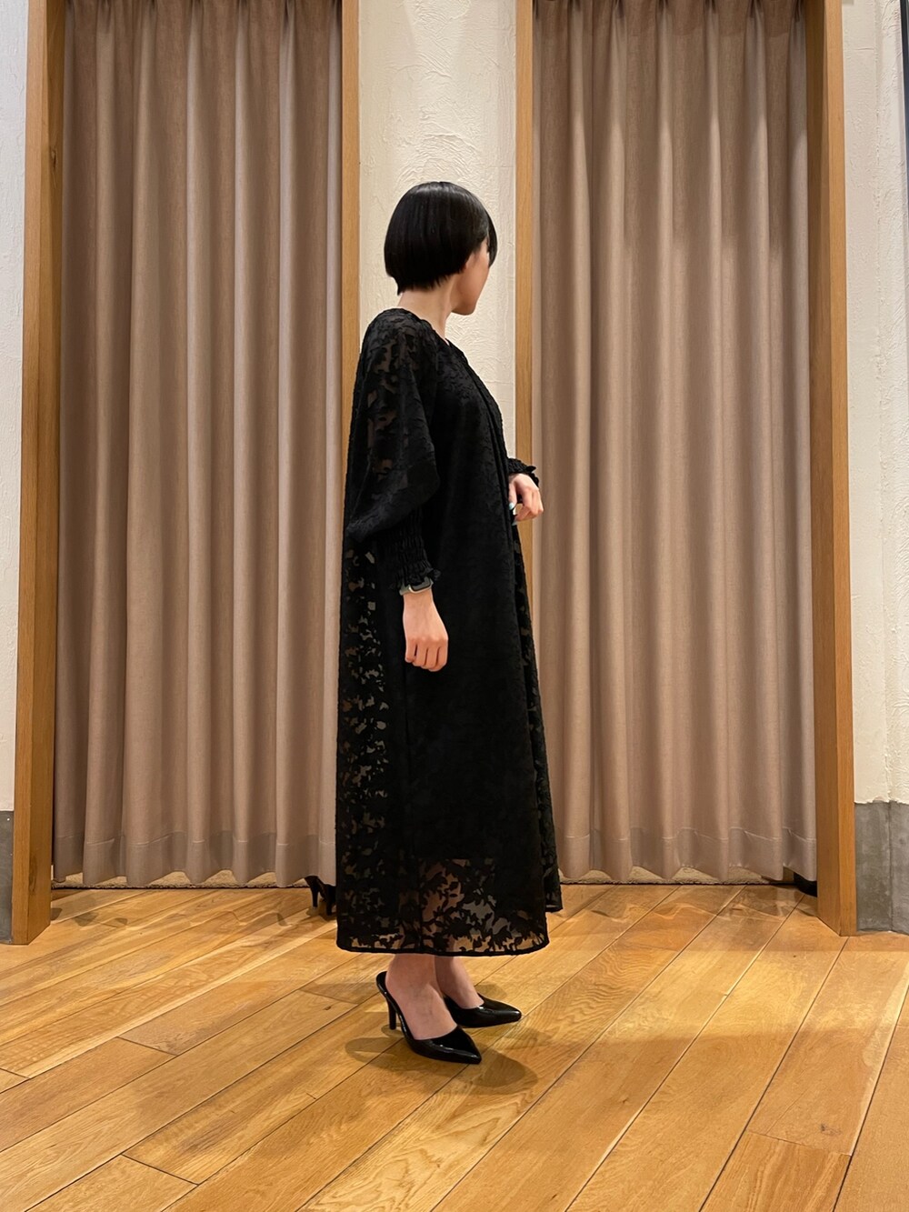 ブラック系のワンピースを着用したレディースの春コーディネートの2枚目の写真