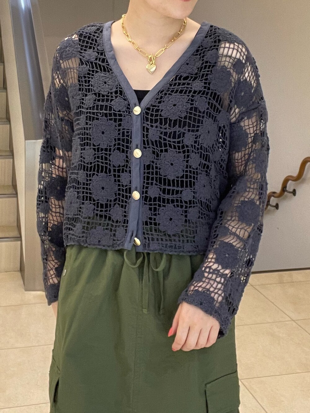 グレー系のカーディガン/ボレロ、グリーン系のスカート、ブラック系のサンダルを着用したレディースの夏コーディネートの4枚目の写真