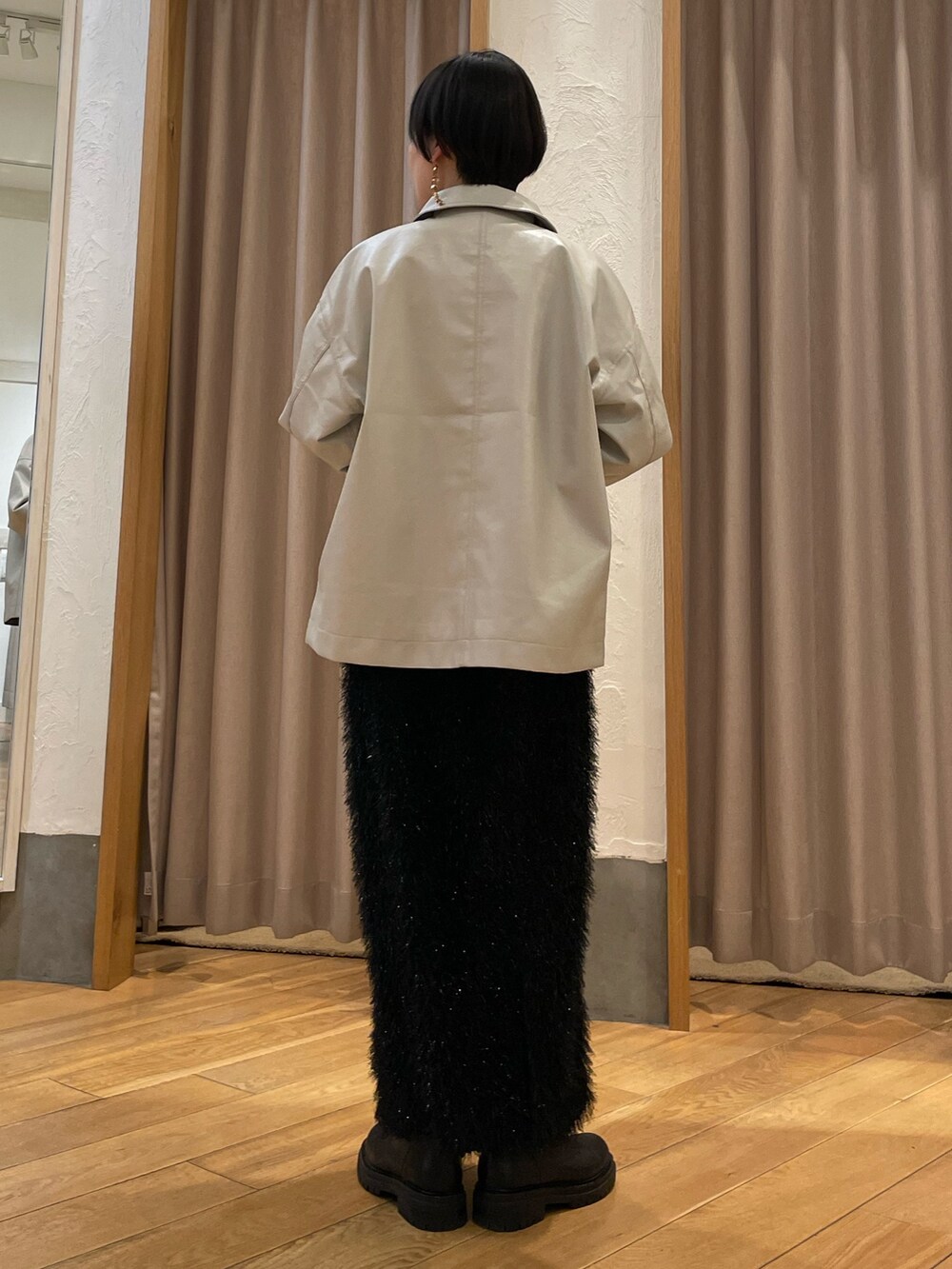ベージュ系のブルゾン、グリーン系のTシャツ/カットソー、ブラック系のスカートを着用したレディースの冬コーディネートの3枚目の写真