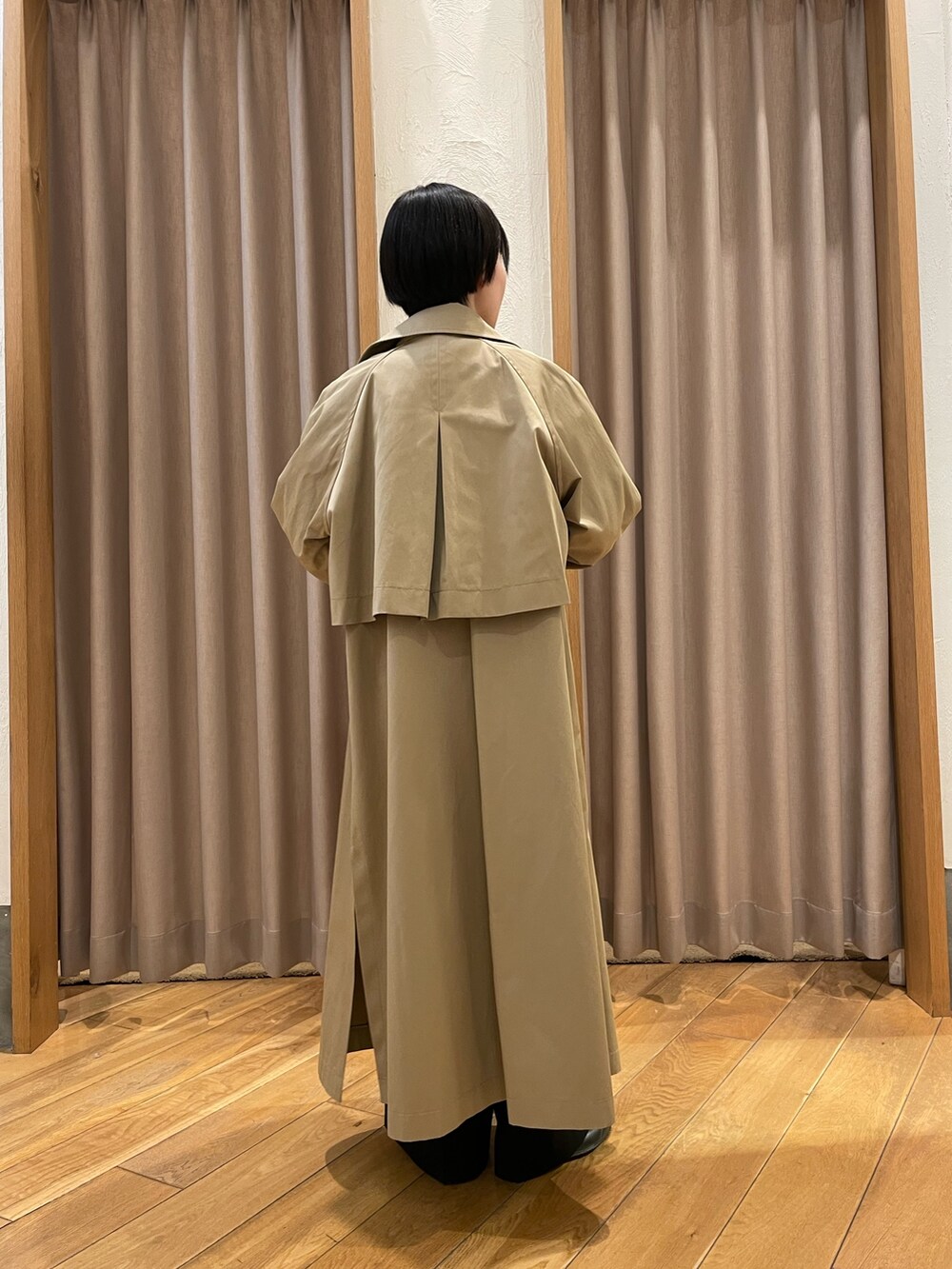 ベージュ系のトレンチコート、ブルー系のシャツ/ブラウス、ブラック系のスラックスを着用したレディースの春コーディネートの3枚目の写真