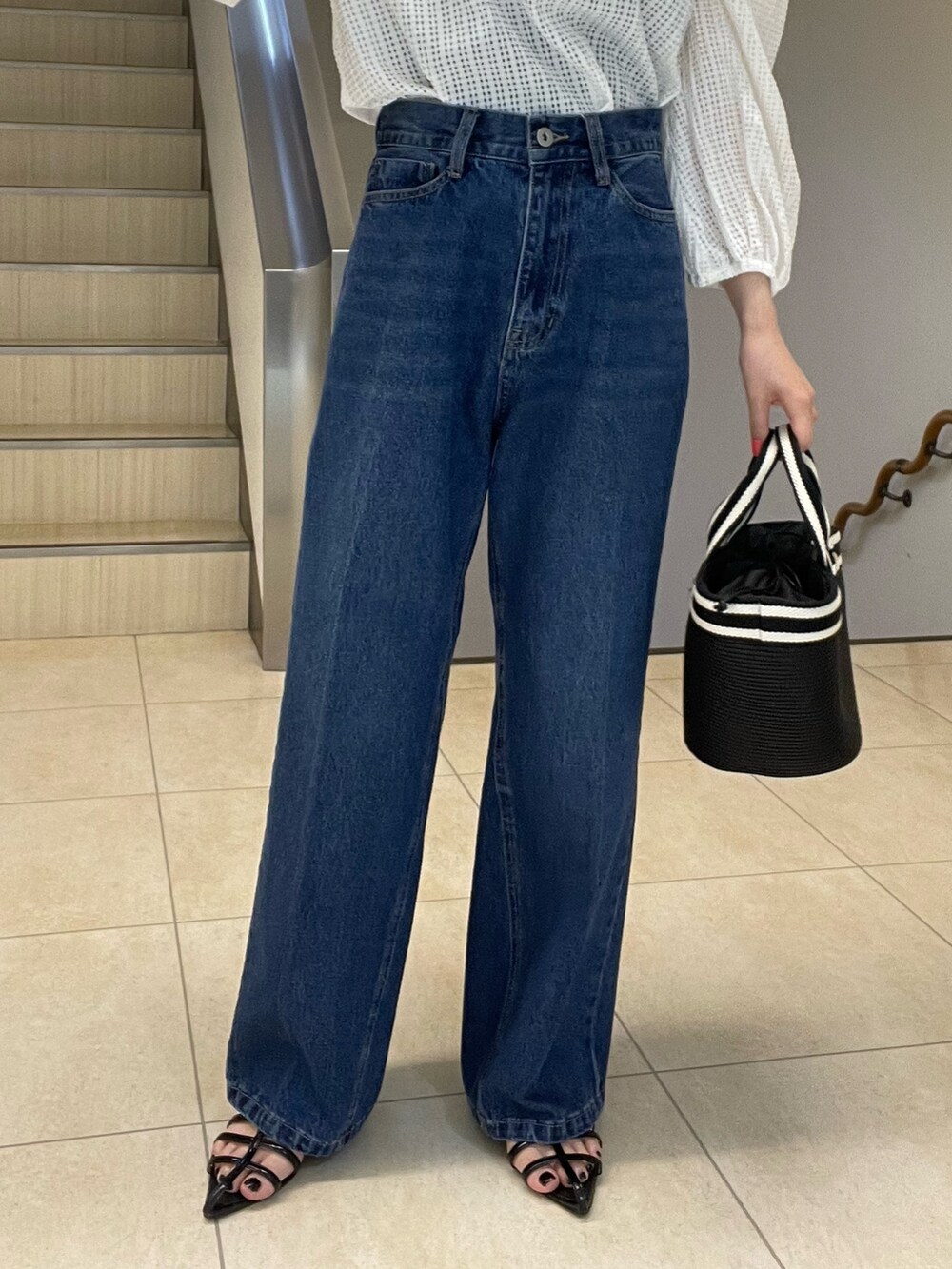ホワイト系のシャツ/ブラウス、ブルー系のデニムパンツ、ブラック系のトートバッグを着用したレディースの春コーディネートの5枚目の写真