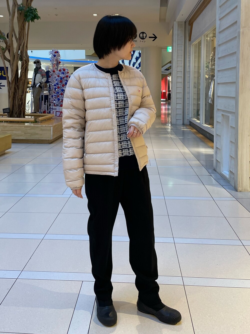 ブルー系のニット/セーター、ホワイト系のダウンジャケット/コート、ブラック系のスラックスを着用したレディースの冬コーディネートの2枚目の写真