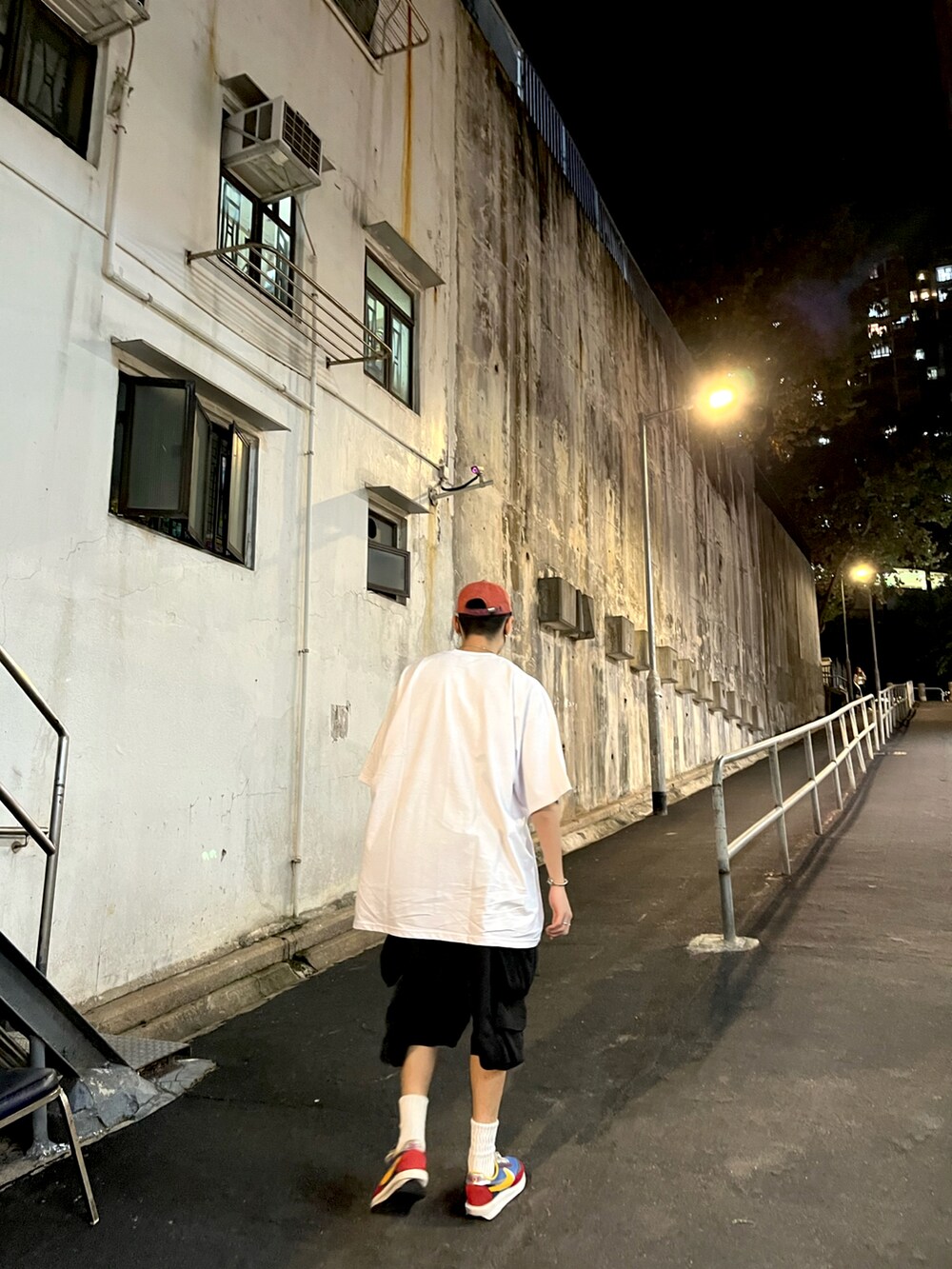 ホワイト系のTシャツ/カットソー、ブルー系のスニーカー、レッド系のキャップを着用したメンズの秋コーディネートの2枚目の写真