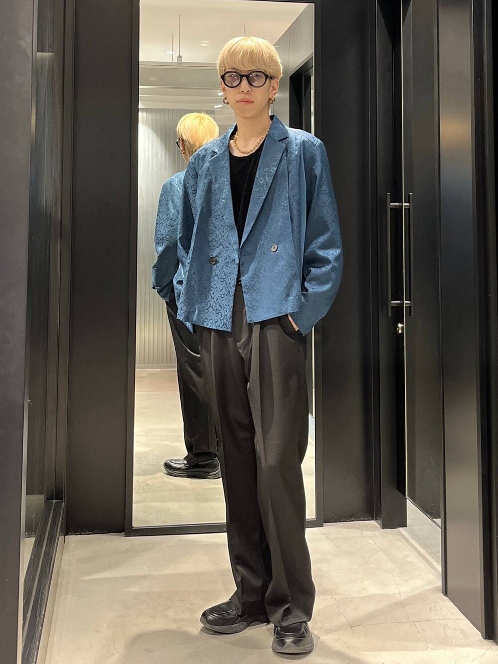 ブラック系のスラックス、グリーン系のテーラードジャケット、ブラック系のベルトを着用したメンズの春コーディネートの2枚目の写真