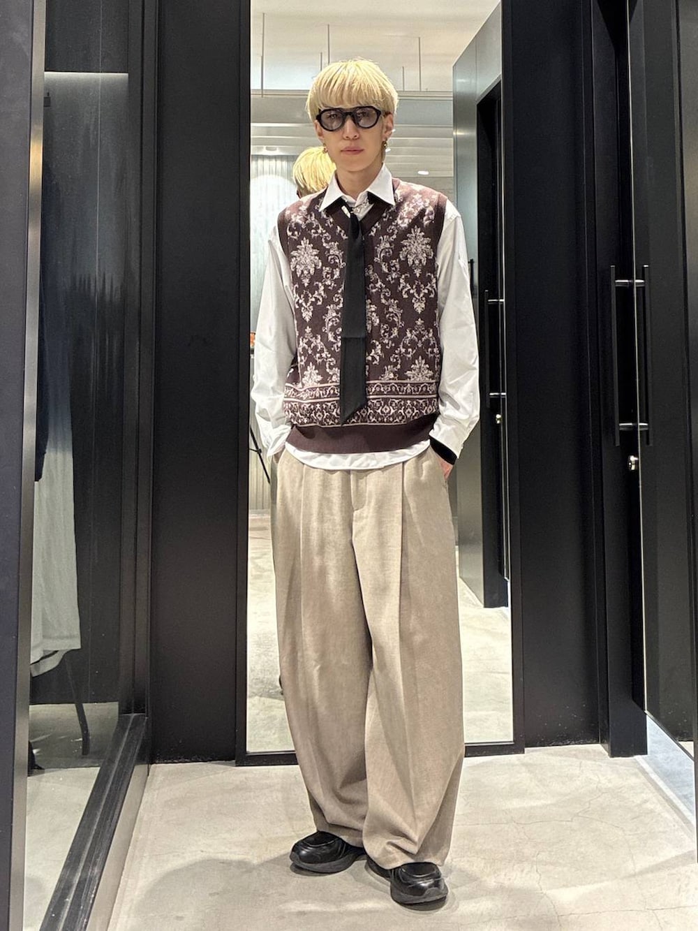 ベージュ系のスラックス、ホワイト系のシャツ/ブラウス、ブラウン系のベストを着用したメンズの春コーディネートの2枚目の写真