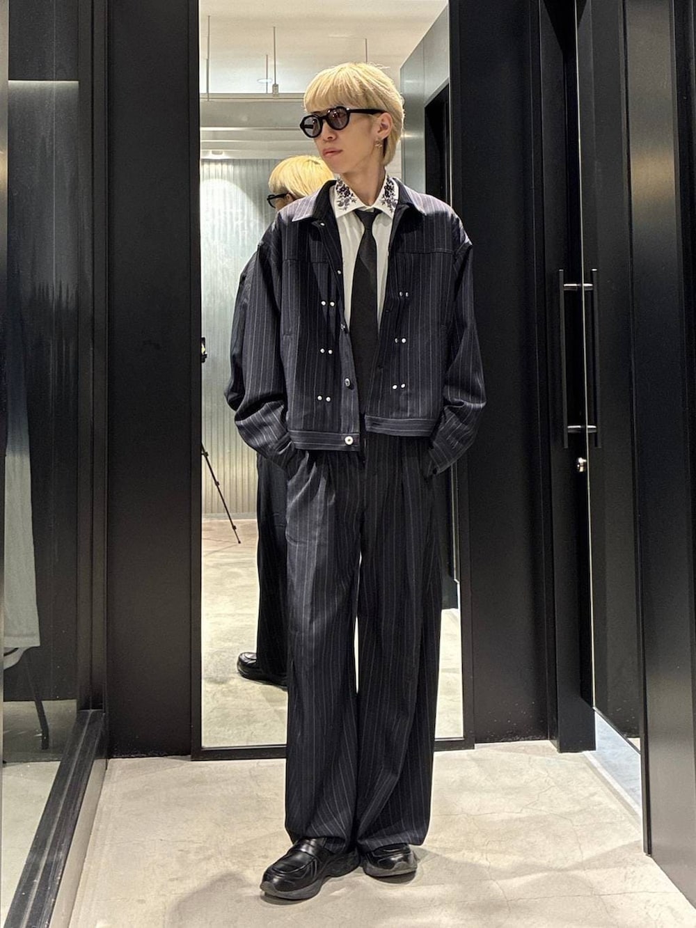 ブラック系のネクタイ、ホワイト系のシャツ/ブラウス、ブルー系のスラックスを着用したメンズの春コーディネートの2枚目の写真