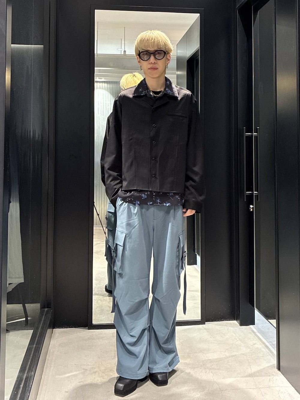 ブルー系のカーゴパンツ、ブラック系のサンダル、ブラック系のシャツ/ブラウスを着用したメンズの春コーディネートの2枚目の写真