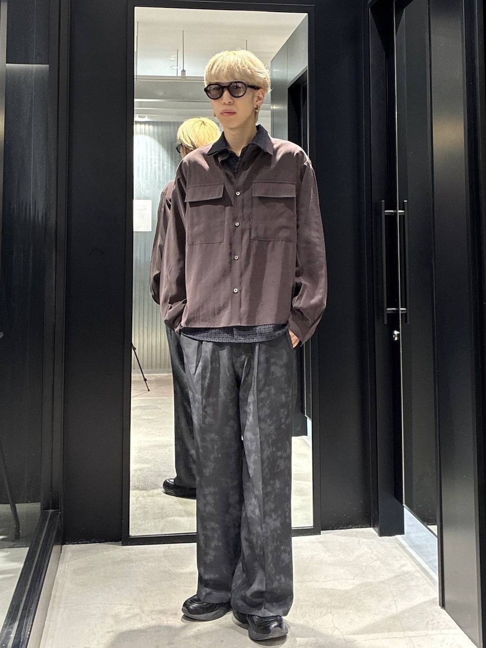 グレー系のスラックス、ブラウン系のシャツ/ブラウス、ブラック系のシャツ/ブラウスを着用したメンズの春コーディネートの3枚目の写真