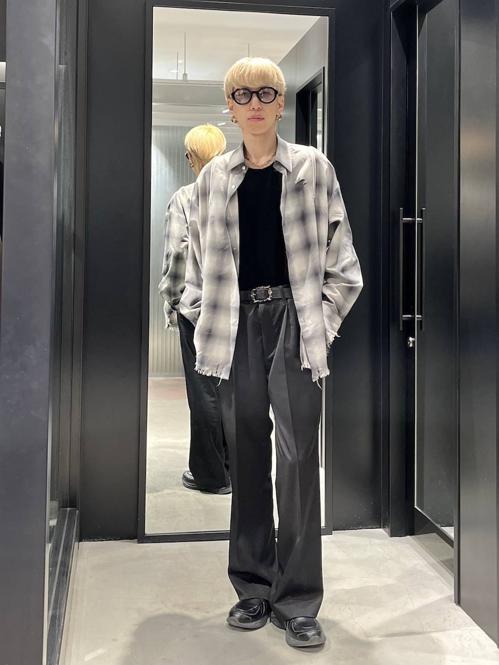 ブラック系のスラックス、ホワイト系のシャツ/ブラウス、ブラック系のベルトを着用したメンズの春コーディネートの2枚目の写真