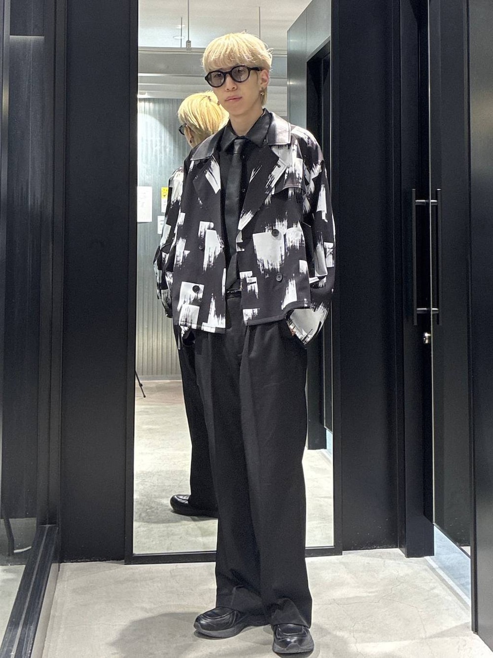 ブラック系のスラックス、ブラック系のシャツ/ブラウス、ブラック系のブルゾンを着用したメンズの春コーディネートの2枚目の写真