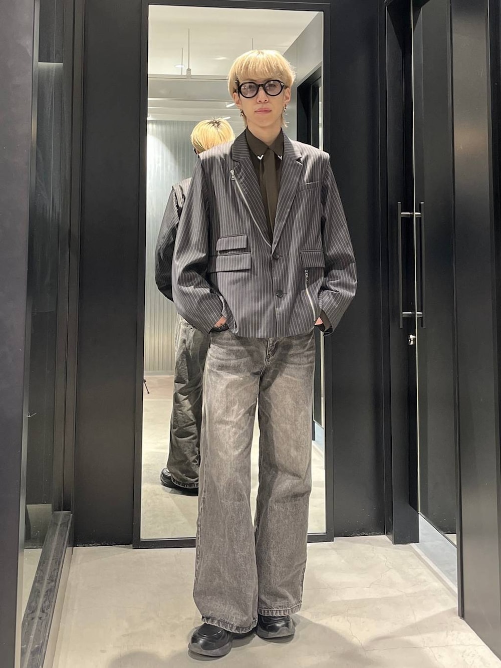 ブラウン系のデニムパンツ、グレー系のテーラードジャケット、ブラウン系のシャツ/ブラウスを着用したメンズの冬コーディネートの2枚目の写真