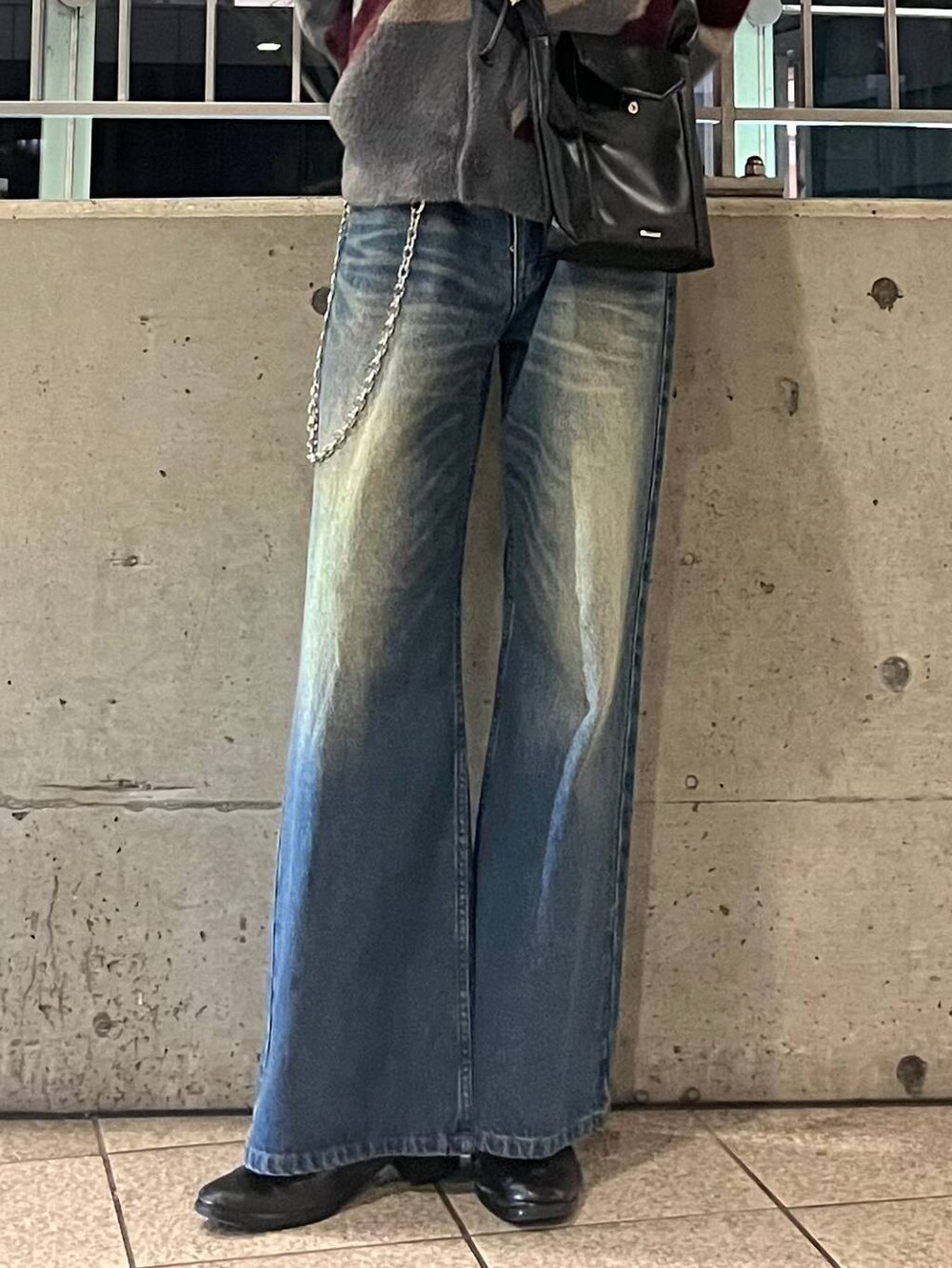 ブルー系のデニムパンツ、グレー系のTシャツ/カットソー、レッド系のカーディガン/ボレロを着用したメンズの秋コーディネートの3枚目の写真