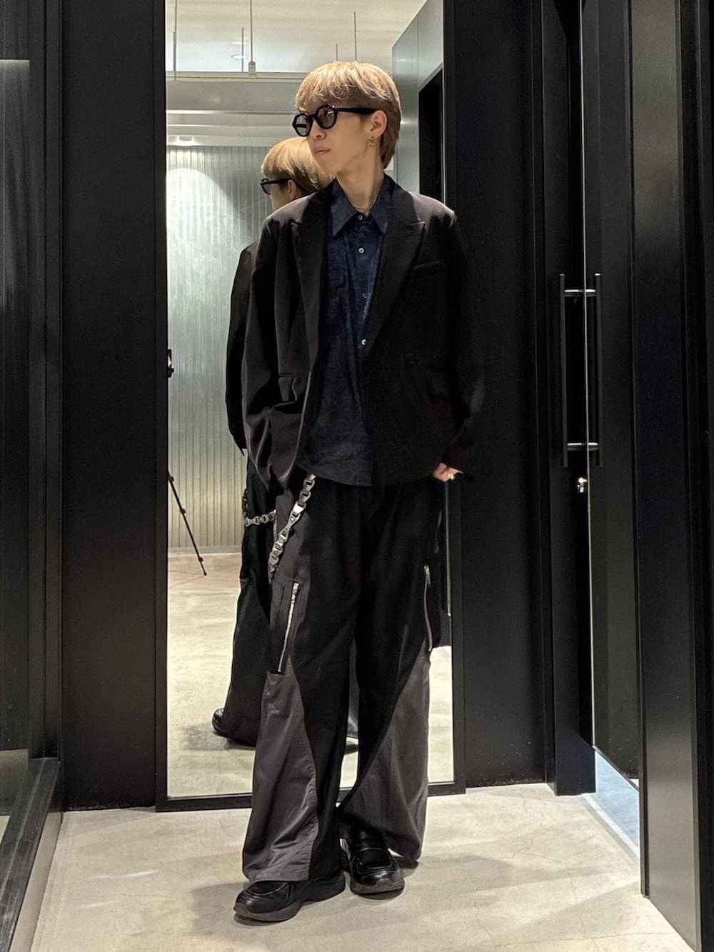 ブラック系のテーラードジャケット、ブラック系のその他パンツ、ブルー系のシャツ/ブラウスを着用したメンズの春コーディネートの2枚目の写真