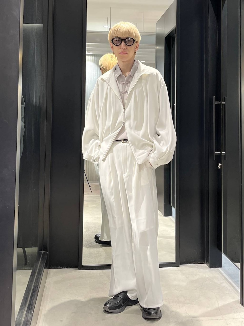 ホワイト系のスラックス、ホワイト系のブルゾン、グレー系のシャツ/ブラウスを着用したメンズの春コーディネートの2枚目の写真