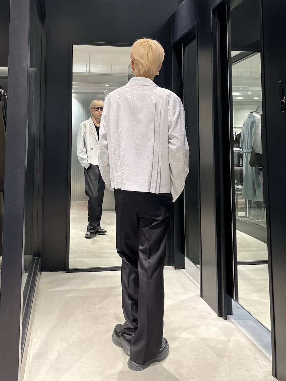 ブラック系のスラックス、グレー系のテーラードジャケット、ブラック系のベルトを着用したメンズの春コーディネートの3枚目の写真