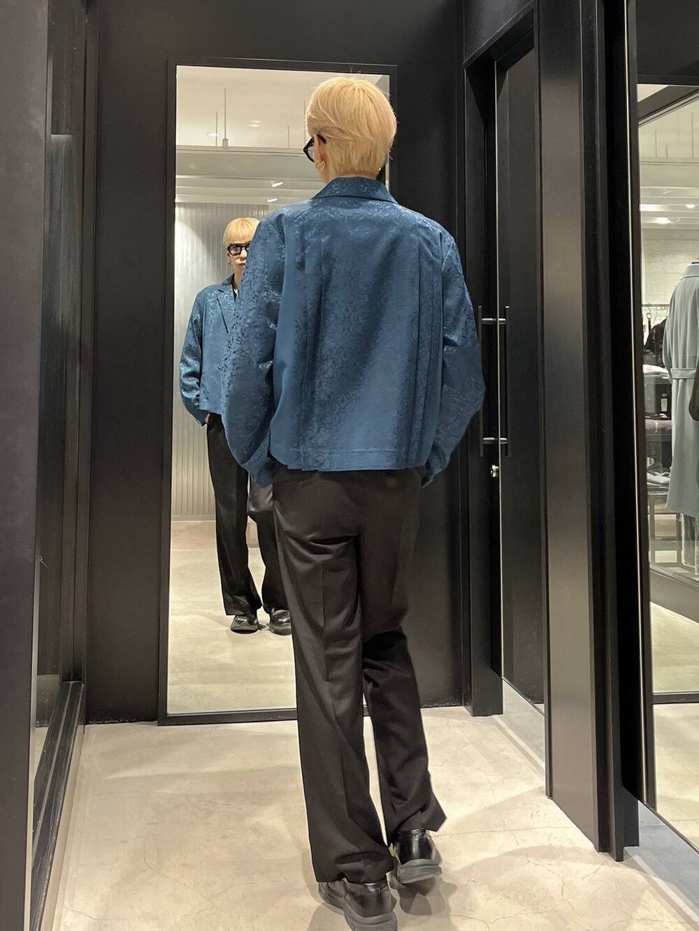 ブラック系のスラックス、グリーン系のテーラードジャケット、ブラック系のベルトを着用したメンズの春コーディネートの3枚目の写真