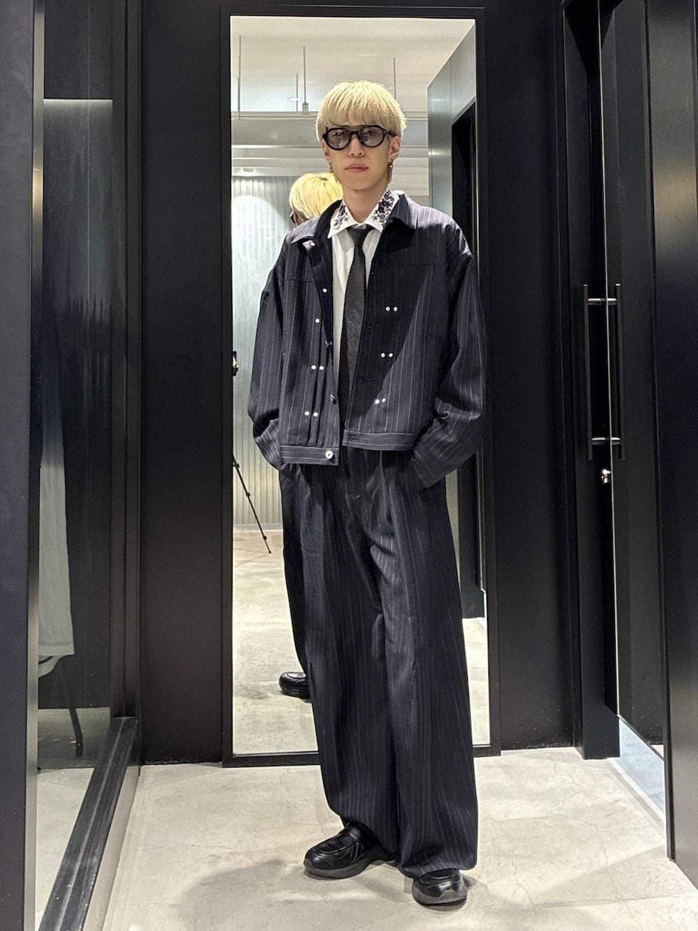 ブラック系のネクタイ、ホワイト系のシャツ/ブラウス、ブルー系のスラックスを着用したメンズの春コーディネートの3枚目の写真