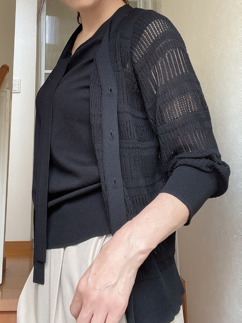 ブラック系のニット/セーター、ブラック系のカーディガン/ボレロ、ベージュ系のその他パンツを着用したレディースの夏コーディネートの2枚目の写真