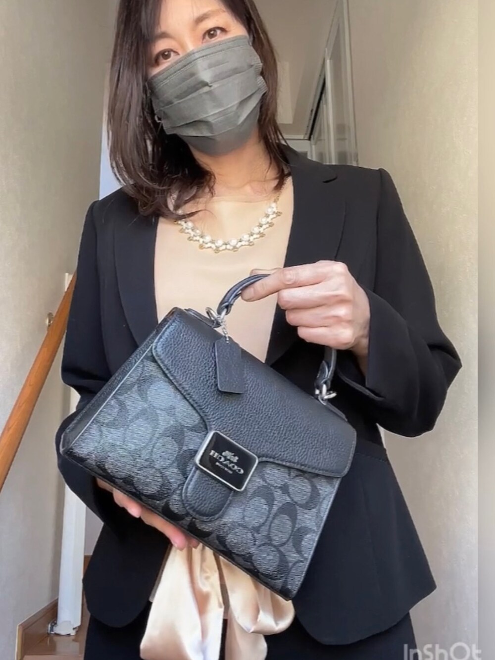 ブラック系のハンドバッグを着用したレディースの春コーディネートの3枚目の写真