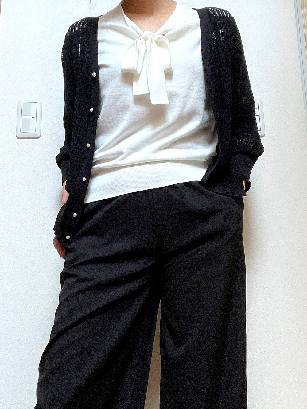 ホワイト系のニット/セーター、ブラック系のカーディガン/ボレロを着用したレディースの夏コーディネートの2枚目の写真