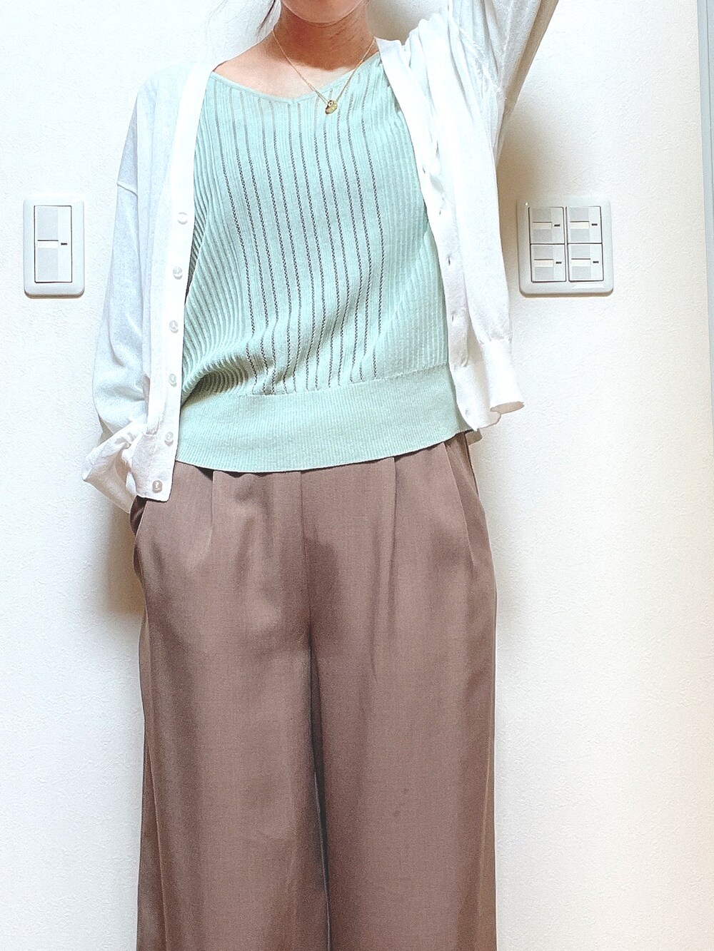 グリーン系のニット/セーター、ホワイト系のカーディガン/ボレロを着用したレディースの夏コーディネートの2枚目の写真