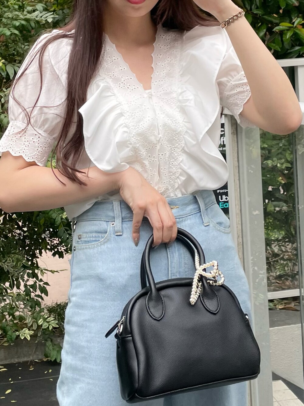 ブルー系のデニムパンツ、ホワイト系のサンダルを着用したレディースの夏コーディネートの2枚目の写真