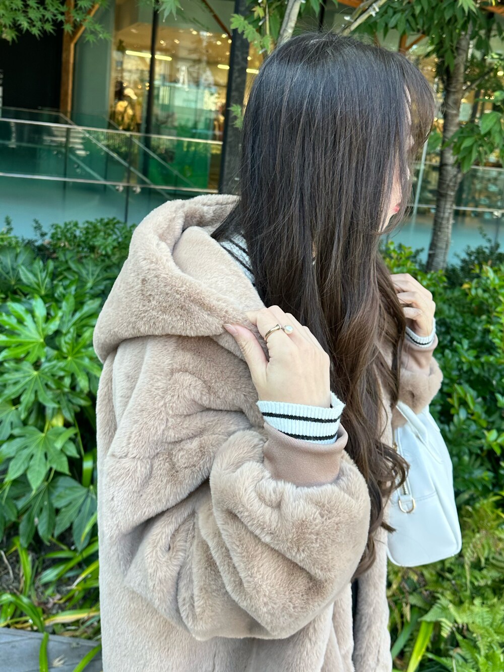 ブラック系のニット/セーター、ブラウン系のブルゾン、ブラック系のスカートを着用したレディースの秋コーディネートの3枚目の写真