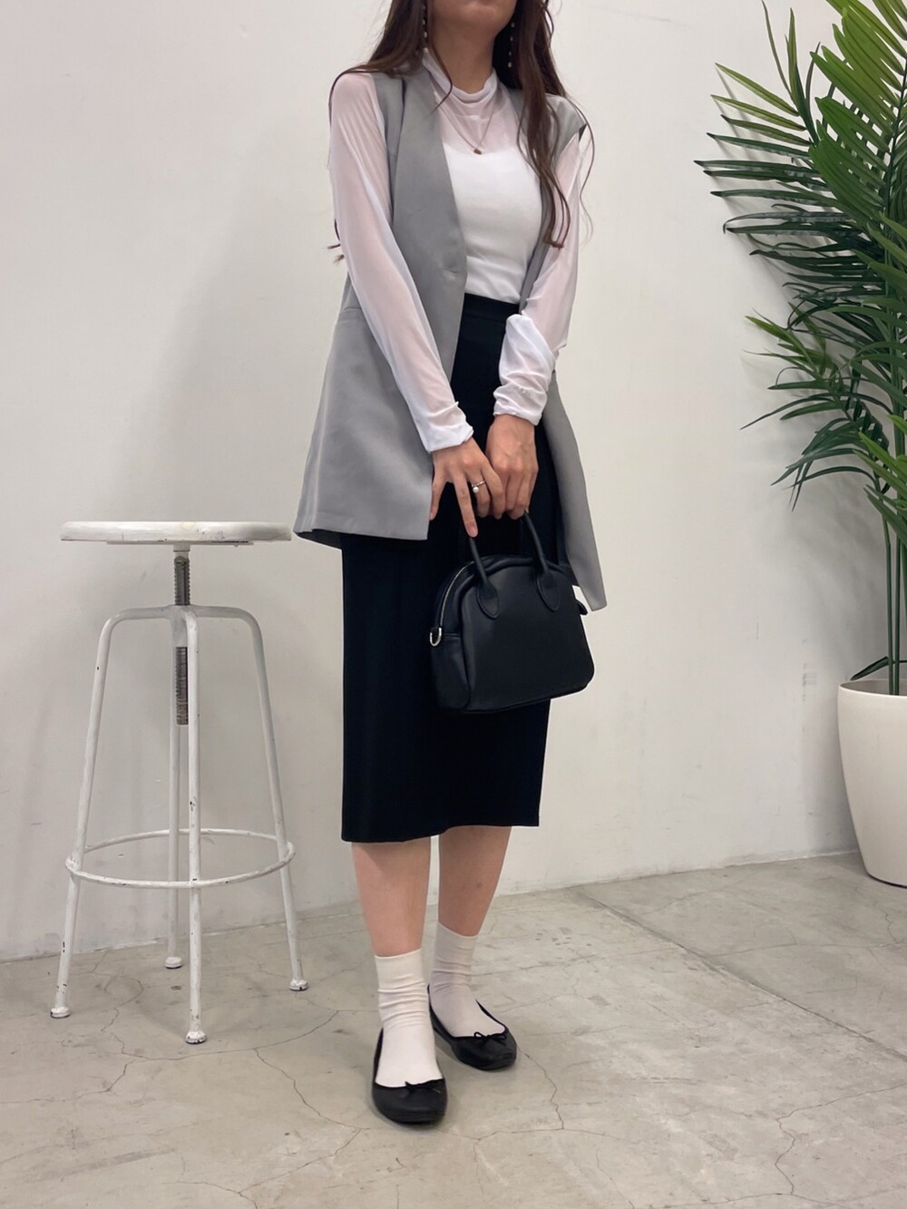 ブラック系のスカート、ホワイト系のTシャツ/カットソー、グレー系のベストを着用したレディースの夏コーディネートの2枚目の写真
