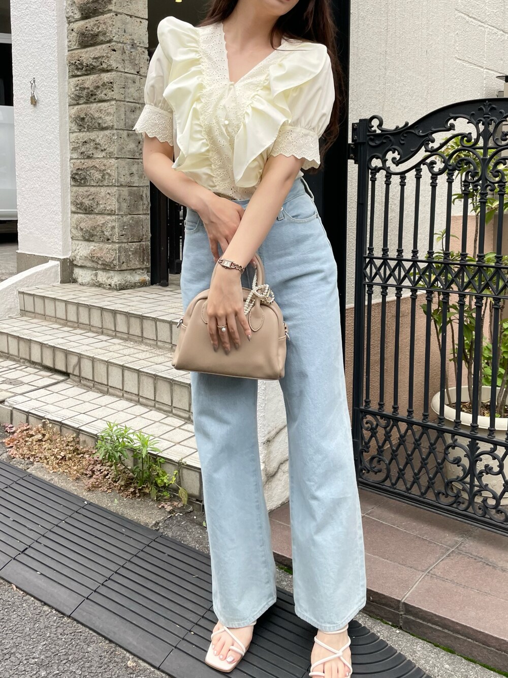 ブルー系のデニムパンツ、ホワイト系のサンダルを着用したレディースの夏コーディネートの2枚目の写真